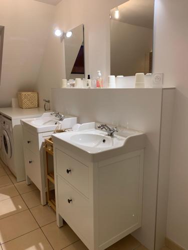 a bathroom with two sinks and a mirror at Golf et sentiers côtiers GR34 in Carantec