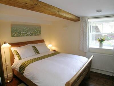 um quarto com uma cama branca e uma janela em Mouse Castle Barn em Hay-on-Wye