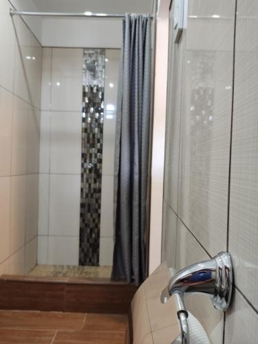 een badkamer met een douche, een wastafel en een douche bij Condominio confortable in Talara