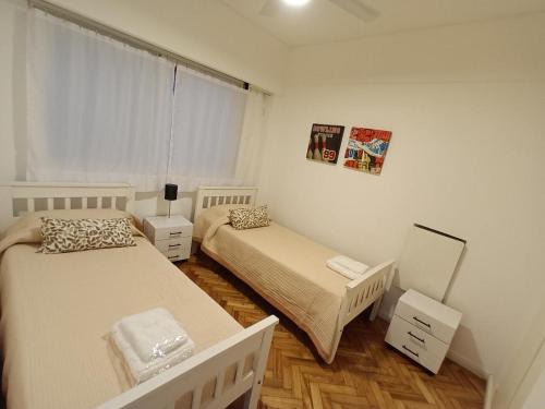 Habitación pequeña con 2 camas y espejo. en Caballito Apartamen Premiun en Buenos Aires