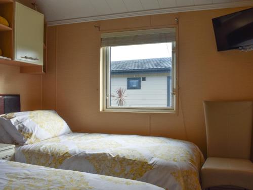 a bedroom with two beds and a window at Sunset Lodge in Llanddulas