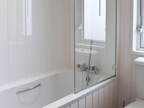 a bathroom with a bath tub with a glass shower at Sunset Lodge in Llanddulas