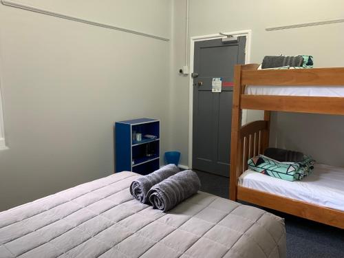 a bedroom with two beds and a bunk bed at Thomas's Catlins Lodge and Camp Ground in Owaka