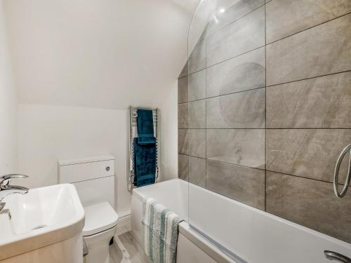 een badkamer met een wit bad en een wastafel bij Salix 3 - Uk46115 in Wigginton