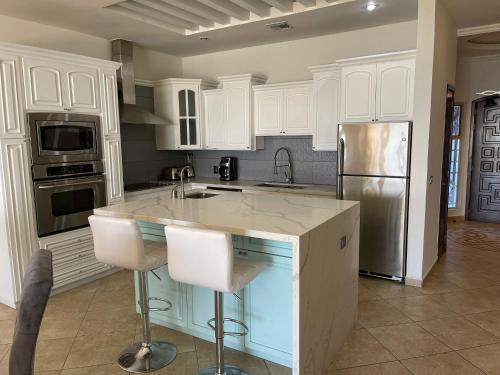 a kitchen with white cabinets and a stainless steel refrigerator at Sonoran Sky Resort Vista a Playa Azul in Puerto Peñasco