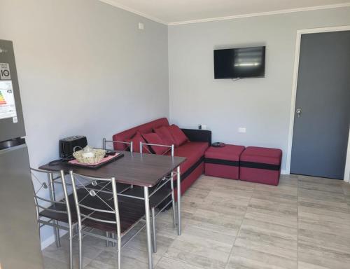 a living room with a red couch and a table at Arriendo diario en Valdivia in Valdivia