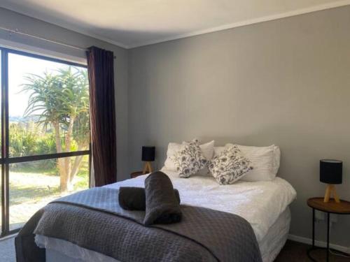 a bedroom with a bed with a large window at Country Life in Tauranga