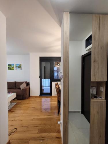 a living room with a couch and a wooden floor at Apartman Lux Titova Vila Plus Sony PS in Zlatibor