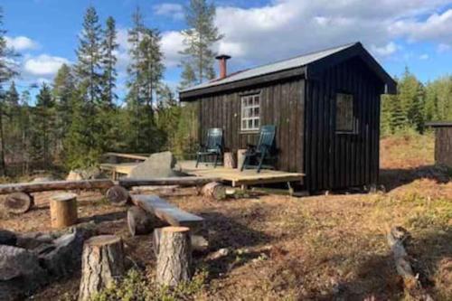 a small cabin with a picnic table and chairs outside at Velkommen til Finnskogen og minihytta Rimbila in Kongsvinger