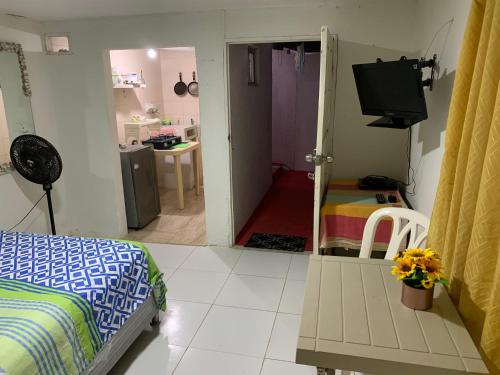 a bedroom with a bed and a room with a kitchen at Habitación independiente cerca al mar. in Puerto Salgar