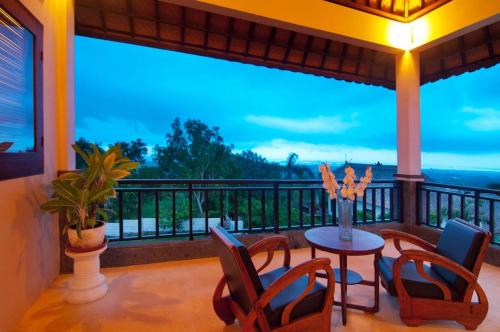 a room with a balcony with a table and chairs at Villa Ultimo in Uluwatu