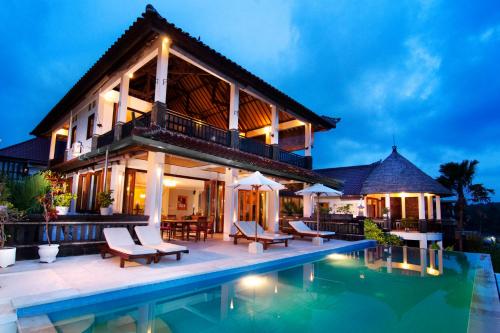 a villa with a swimming pool at night at Villa Ultimo in Uluwatu