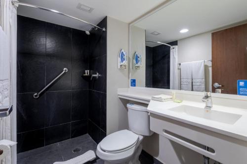 a bathroom with a toilet and a sink and a shower at City Express by Marriott Guadalajara Aeropuerto in Guadalajara