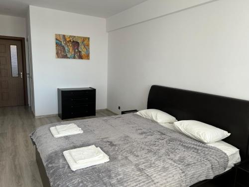 a bedroom with a bed with two towels on it at Lucky Apartment in Braşov
