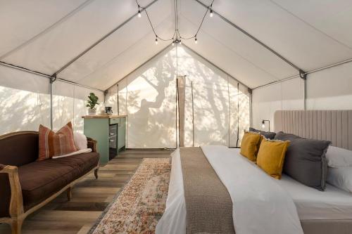 a bedroom with a bed and a couch in a tent at Oak Retreat Glamping With Private Hot tub in Luckenbach