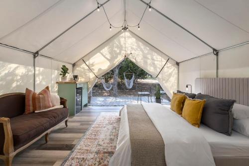 a bedroom with a bed and a couch in a tent at Oak Retreat Glamping With Private Hot tub in Luckenbach