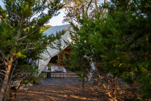 a view of a tent with a deck and trees at Oak Retreat Glamping With Private Hot tub in Luckenbach
