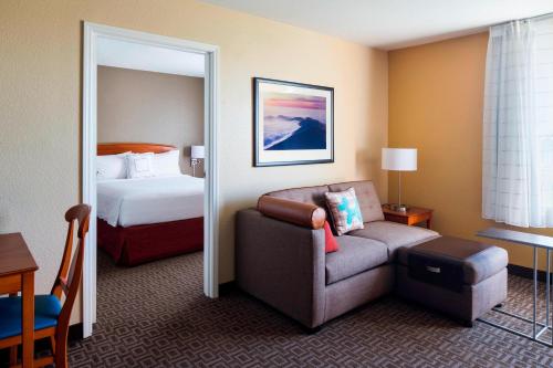 a hotel room with a bed and a couch and a chair at TownePlace Suites Milpitas Silicon Valley in Milpitas