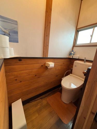 łazienka z toaletą w drewnianej ścianie w obiekcie Snow Fever - Clan w mieście Hakuba