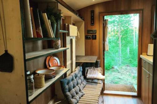 una sala de estar con un banco en una casa pequeña en Off-grid minihus på Finnskogen., en Kongsvinger