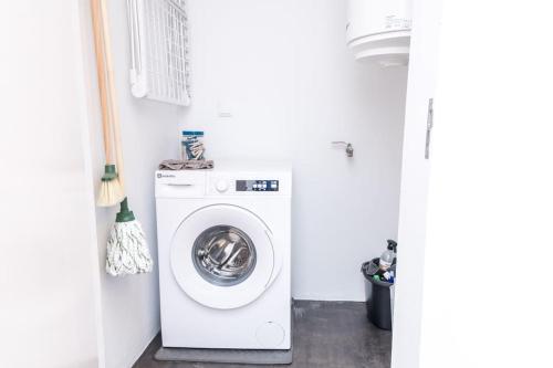 a white laundry room with a washing machine at MAR NEST Lodging - New & cosy house for 2, fully equiped & sea view in Glória