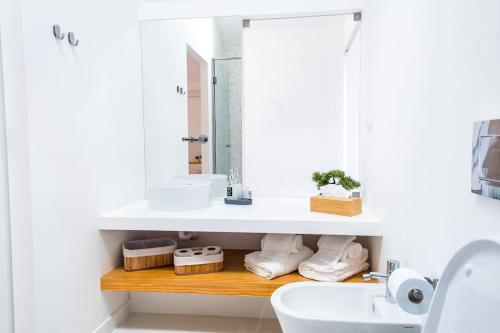 uma casa de banho branca com um lavatório e um espelho em MAR NEST Lodging - New & cosy house for 2, fully equiped & sea view em Glória