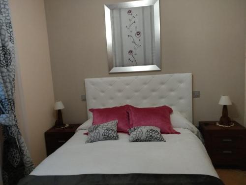 a bedroom with a white bed with two pillows at Maria Santian in Arcones