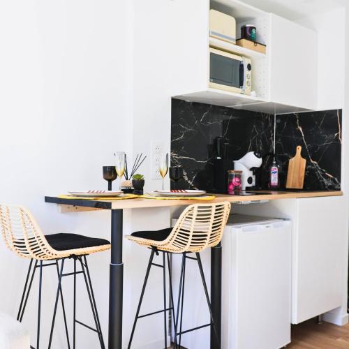une cuisine avec une table et deux tabourets dans l'établissement Studio EASY CHECK-IN 8 mins Disneyland 35 mins Paris FREE Starbucks coffee parking wifi, à Bussy-Saint-Georges