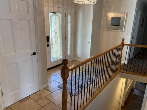 a staircase in a home with a white door and a stair railing at Wasatch Front home with pool close to everything! in Murray
