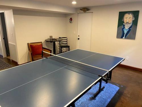 a ping pong table in a living room with a table at Wasatch Front home with pool close to everything! in Murray