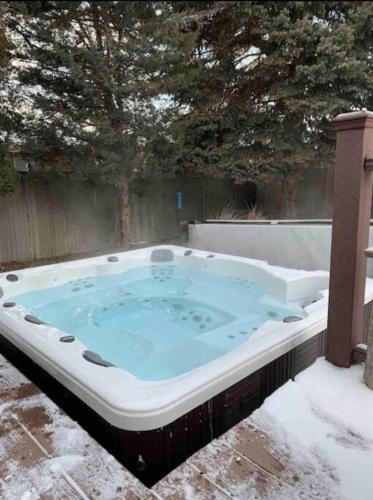a jacuzzi tub in a yard in the snow at Wasatch Front home with pool close to everything! in Murray