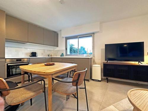 une cuisine avec une table et des chaises et une télévision dans l'établissement Vue exceptionnelle - 4 pers. jardin clim parking, à Saint-Raphaël