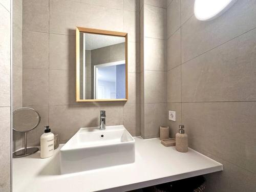 une salle de bain avec un lavabo blanc et un miroir dans l'établissement Vue exceptionnelle - 4 pers. jardin clim parking, à Saint-Raphaël