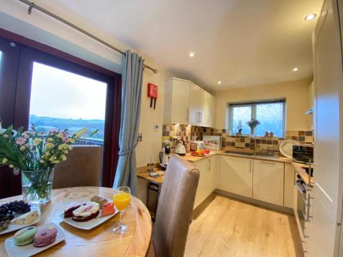 a kitchen and dining room with a table and a window at Lune Cottage nestled between Lake District and Yorkshire Dales in Tebay