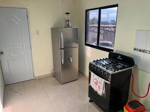 a kitchen with a stove and a refrigerator at El anexos in Santiago de los Caballeros