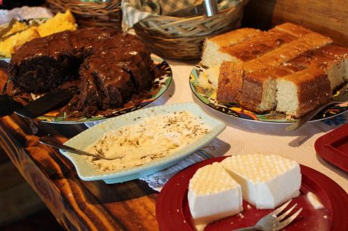 a table topped with different types of cakes and desserts at Chalés de Analuz in Visconde De Maua
