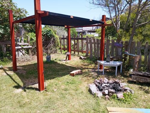 una pérgola y una mesa en un patio en Es acá., en Rocha