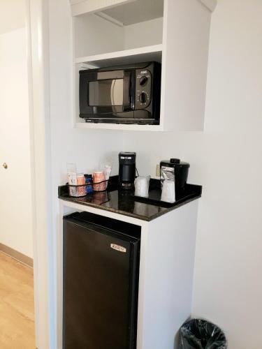 a microwave above a small refrigerator in a kitchen at Comfort Suites Valdosta Mall Area in Valdosta