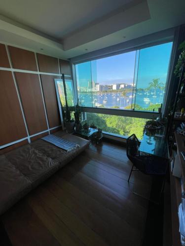 Habitación con ventana grande y sofá enfrente. en Apartamento Urca, en Río de Janeiro