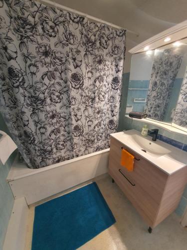 uma casa de banho com um lavatório e uma cortina de chuveiro em Proche Paris-Château Versailles-St Germain em Marly-le-Roi
