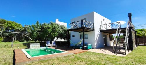 a villa with a swimming pool and a house at Casa a media cuadra de la playa in Balneario Buenos Aires