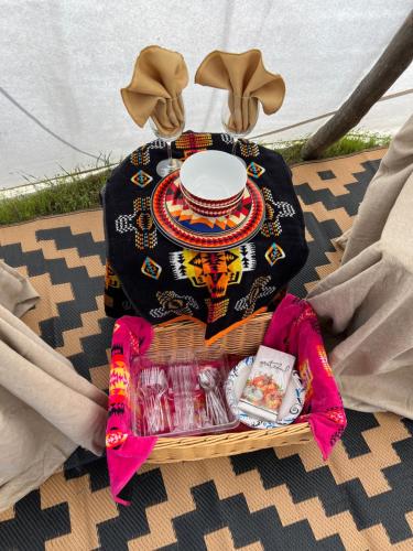 una mesa con una cesta con un plato y un sombrero en JMA Tipi, en Riverton