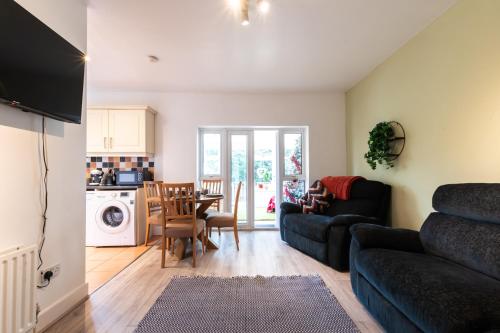 uma sala de estar com um sofá e uma mesa em Accessible 3-bedroom bungalow with patio +driveway em Southampton