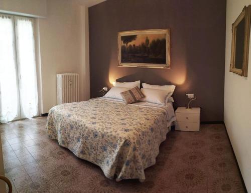 1 dormitorio con 1 cama y una pintura en la pared en le case di Giulia, en Abbadia Lariana