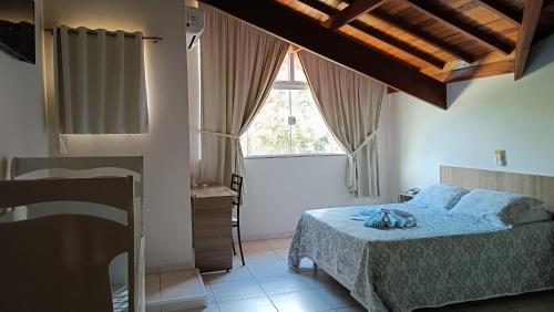 um quarto com uma cama e uma janela em Pousada Mandala Botucatu em Botucatu