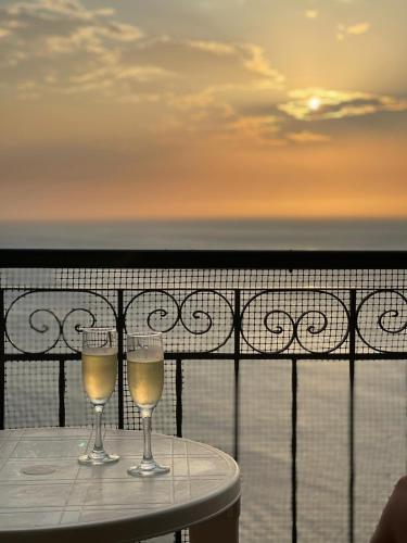 dos copas de vino sentadas en una mesa en un balcón en El Peñon increible vistas al oceano Torre B, en Santa Marta