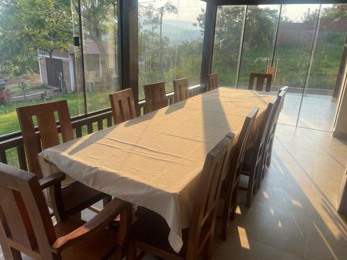 tavolo e sedie in una stanza con una grande finestra di Gästehaus Samaipata a Samaipata