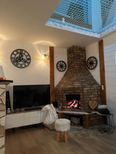 sala de estar con TV y chimenea en Ranc kod Keme en Trnovo