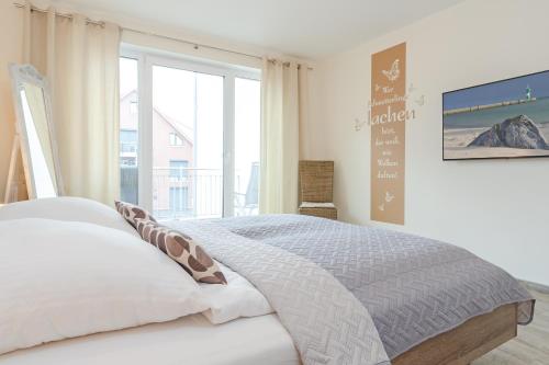 een slaapkamer met een bed en een groot raam bij Esprit 4 in Scharbeutz