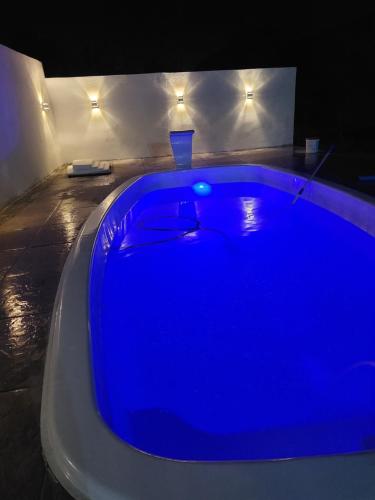 uma banheira de hidromassagem azul num quarto à noite em Casa Praia de Xangri-Lá Piscina em Xangri-lá